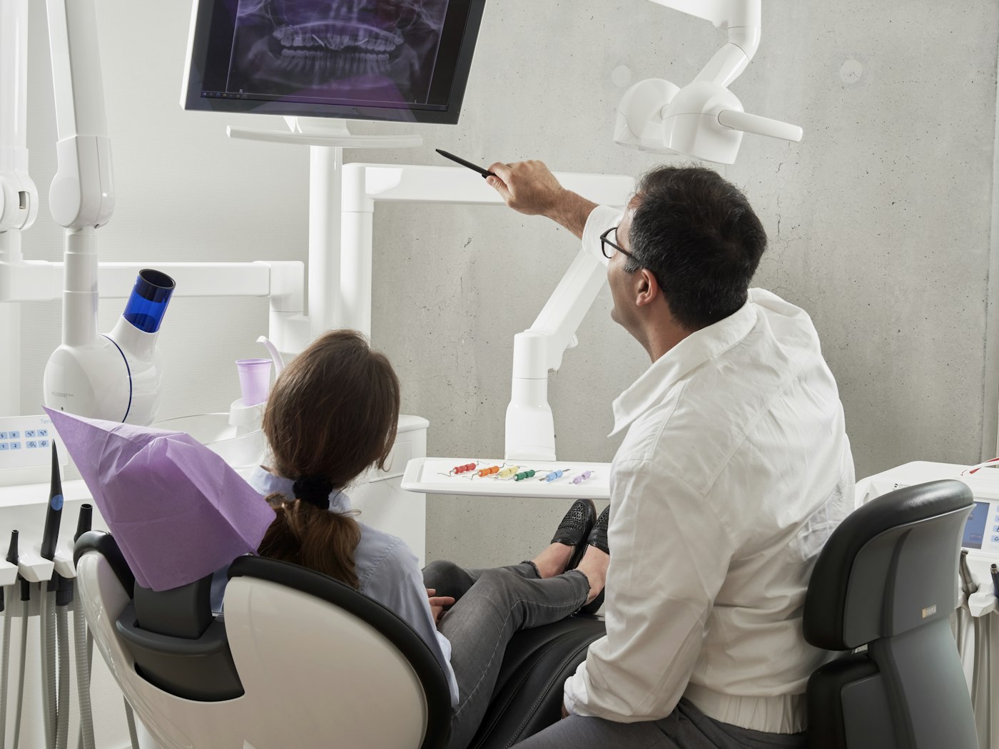 Dentista explicando el tratamiento a un paciente